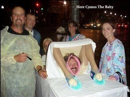 1991 Ford Bronco - A group of people dressed in medical scrubs are gathered around a prop baby, seemingly celebrating a humorous event.
