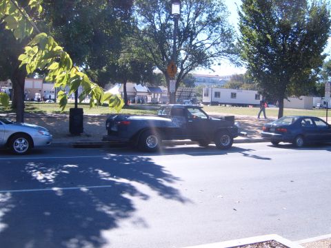 1988 Ford Bronco - A modified pickup truck is parked on the street next to two other cars.