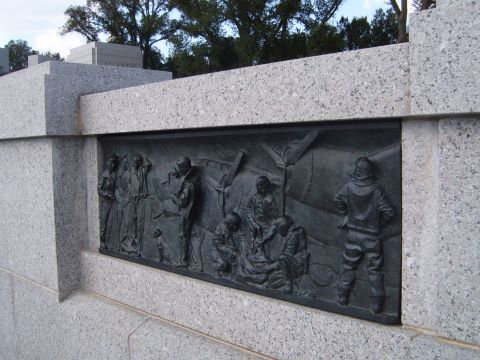 1988 Ford Bronco - A detailed bas-relief sculpture is set into a granite wall, showing figures and an aircraft.