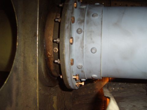 1988 Ford Bronco - Close-up view of a bolted flange connection on a large pipe, with visible rust and wear on the metal components.