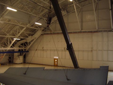 1988 Ford Bronco - An aircraft wing is seen in a large hangar, with a crane positioned above.