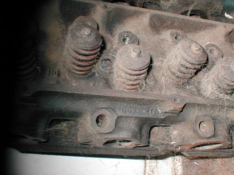 1979 Ford Bronco - This is a close-up view of a dusty engine cylinder head, showing valve springs and some cast-in text.