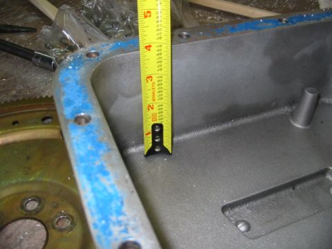 1997 Ford Crown Victoria - A yellow measuring tape is placed inside a metal engine oil pan, showing its depth.
