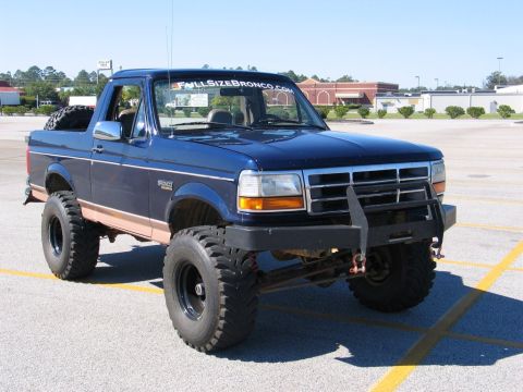 1995 Ford Bronco - This modified Ford Bronco features a lifted suspension and aggressive off-road tires, with a custom brush guard.