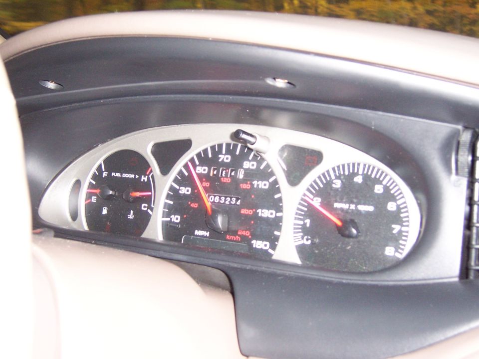 Car dashboard showing speedometer, tachometer, fuel gauge, and odometer reading 063234