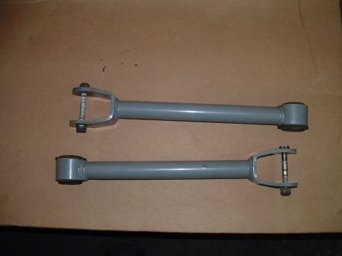 1994 Ford Bronco - Two gray control arms are shown against a brown background, with a Supermotors.net watermark at the bottom.