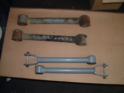 1994 Ford Bronco - Comparison of old and new control arms for a vehicle suspension system.