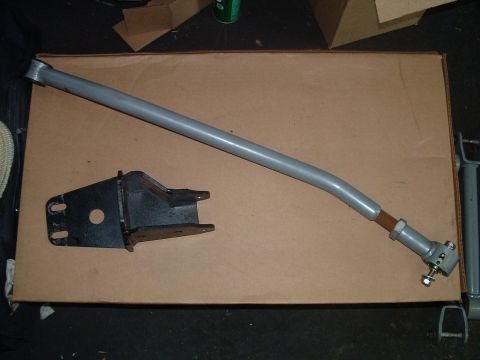1994 Ford Bronco - Automotive steering linkage rod and mounting bracket shown on a cardboard surface.