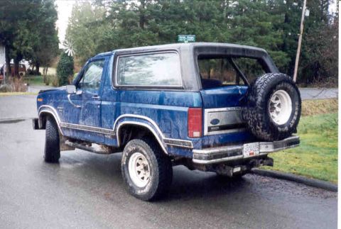 1989 Ford Bronco - This blue 1989 Ford Bronco is seen from the rear, a spare tire mounted on the tailgate.