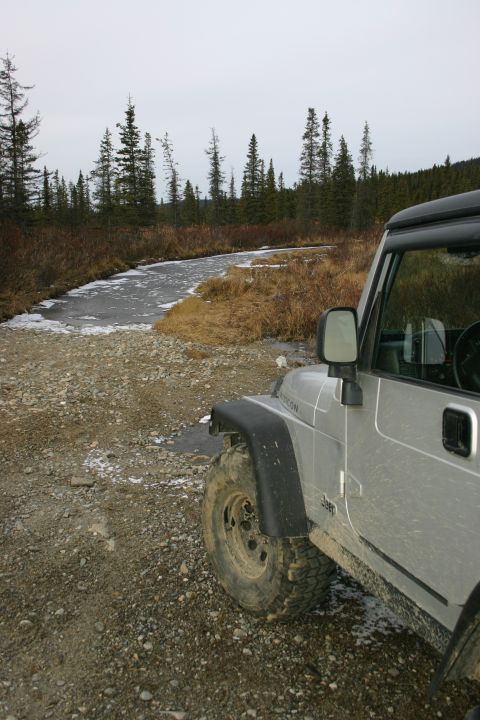 2003 Jeep TJ - Silver 2003 Jeep TJ on a gravel road next to a partially frozen stream.