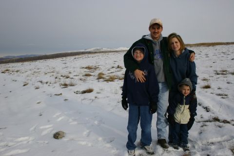 2003 Jeep TJ - A family stands together in a snow-covered landscape under an overcast sky.
