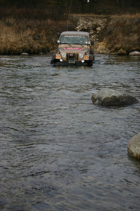 2003 Jeep TJ - Jeep TJ fording a river, showing its front end and a WARN winch.
