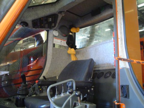 1966 International School Bus - Construction vehicle interior with driver's seat, controls, and dashboard visible. A stuffed toy is hanging.