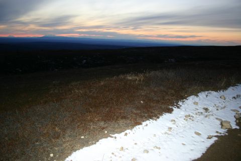 2003 Jeep TJ - A vast, dark landscape is illuminated by a colorful sunset sky, with patches of snow on the ground.