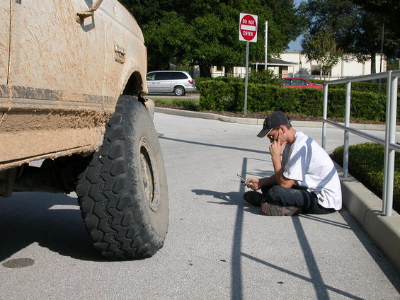 Mud-covered 1989 Ford Bronco side view with large tire
