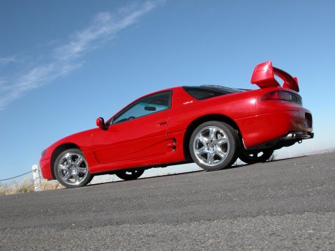 1999 Mitsubishi 3000GT - Side view of a red 1999 Mitsubishi 3000GT with a large rear spoiler.