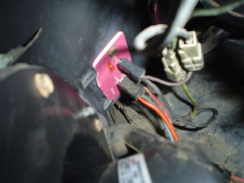 1984 Ford Bronco - A close-up view of a vehicle's wiring harness, showing several connectors and colored wires.