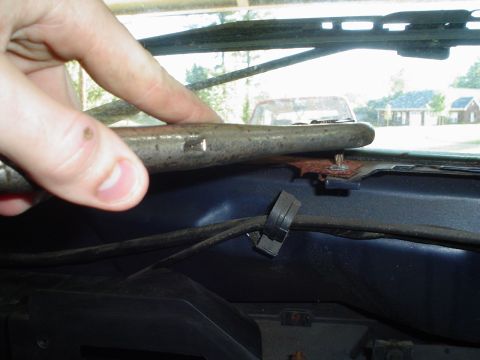 1984 Ford Bronco - A hand points to a metal rod on the dashboard, with another vehicle visible through the windshield.