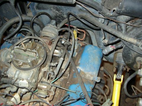 1985 Ford Bronco - Close-up view of an engine bay, showing a carburetor and various hoses and wires.