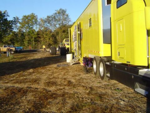 1979 Ford Bronco - A yellow semi-truck and trailer are parked outdoors, with several other vehicles visible in the background.