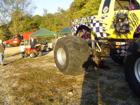 1979 Ford Bronco - A monster truck with custom graphics is parked outdoors near tents and other vehicles.