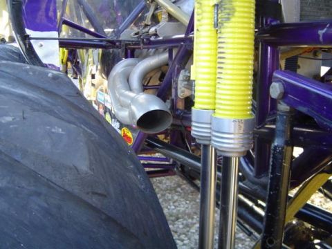 1979 Ford Bronco - Close-up view of exhaust pipes and yellow suspension hoses on a heavily modified vehicle, likely a mud bogger.