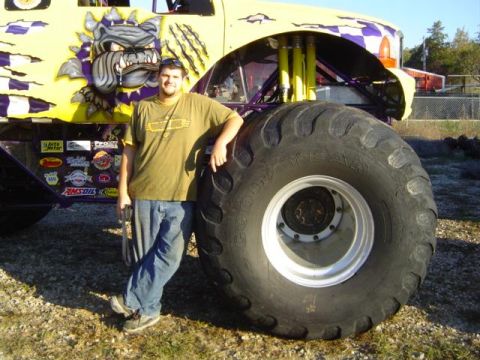 1979 Ford Bronco - A man poses beside a large monster truck adorned with a fierce bulldog graphic and a checkered design.