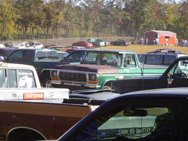 Green 1979 Ford pickup truck with a brown hood, parked at an outdoor event