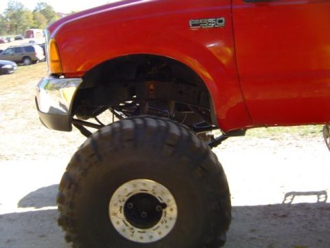 1979 Ford Bronco - A red truck with large tires and "F550" badging is shown from the front quarter angle.