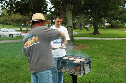 1991 Ford Taurus - Outdoor grilling scene in a park with a car visible in the background.