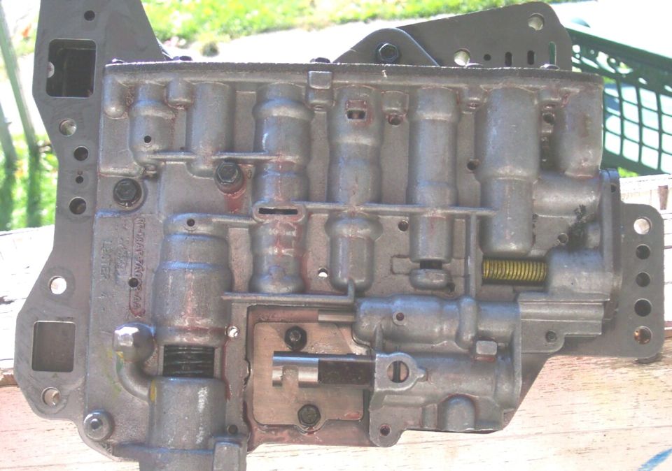 Close-up of an automatic transmission valve body with visible solenoids and springs