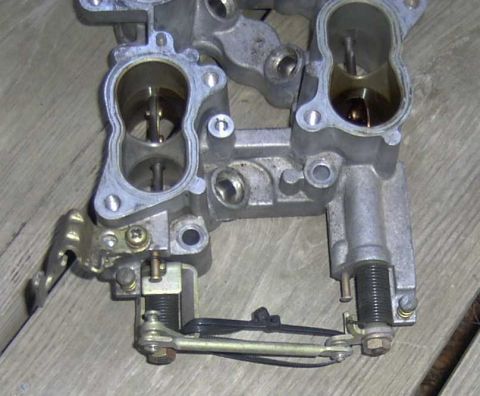 1997 Ford Taurus - Close-up of a throttle body assembly, showing internal components and external linkages.