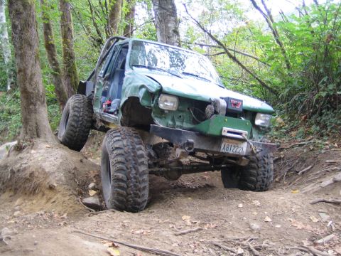 1990 Ford Bronco - This heavily modified SUV navigates a challenging off-road course with its large tires and custom roll cage.
