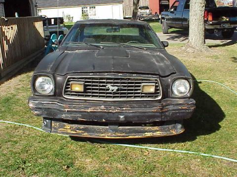 1978 Ford Mustang II - Front view of a 1978 Ford Mustang II with a worn black bumper and grille.