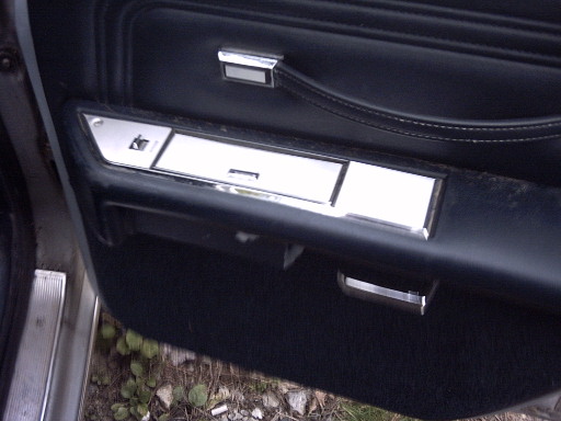 Interior door panel with chrome accents and black upholstery