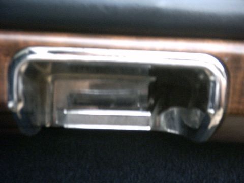 1991 Ford Crown Victoria LTD - Close-up of a car's interior ashtray, showing chrome and wood-grain trim details.