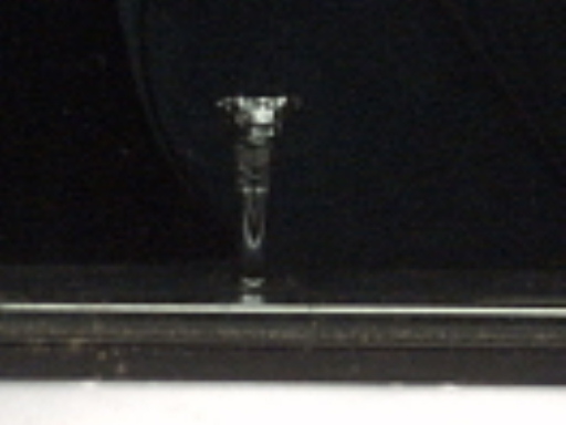 Close-up of a chrome hood ornament on a dark background
