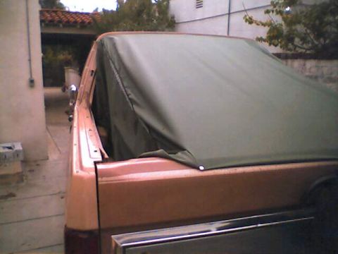1994 Ford Bronco - Rear view of a tan SUV covered with a green soft top.