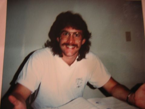 1985 Ford LTD Crown Victoria - A man with a distinctive 1980s hairstyle and facial hair smiles for the camera.
