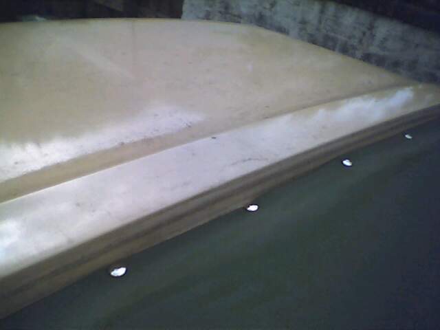 Tan soft top roof with visible mounting holes along the edge