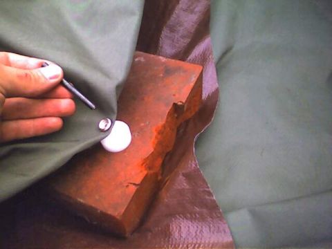 1994 Ford Bronco - A hand is shown securing a metal fastener to a green soft top cover.