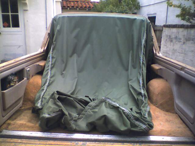 Vehicle interior with green tarp covering the rear section