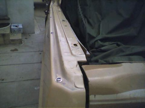 1994 Ford Bronco - A car body panel is partially covered by a tarp, with visible bolts along the edge.