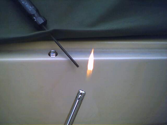 Soft top being heated with a torch near a screw