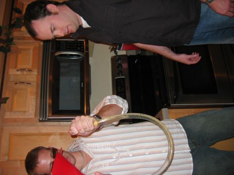 1985 Ford LTD Crown Victoria - A man pours a drink from a tube into a funnel while another man watches.