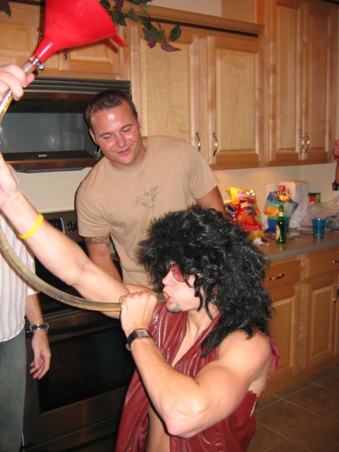 1985 Ford LTD Crown Victoria - Friends participate in a drinking game using a funnel at a party.