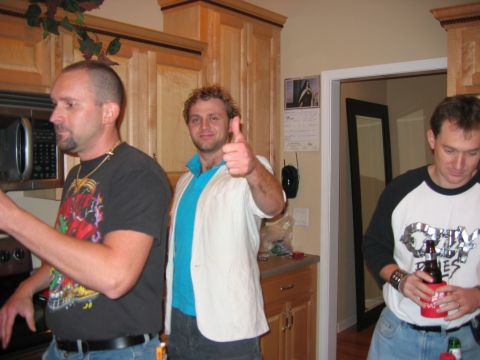 1985 Ford LTD Crown Victoria - Three men are gathered in a kitchen, with one man giving a thumbs-up gesture.