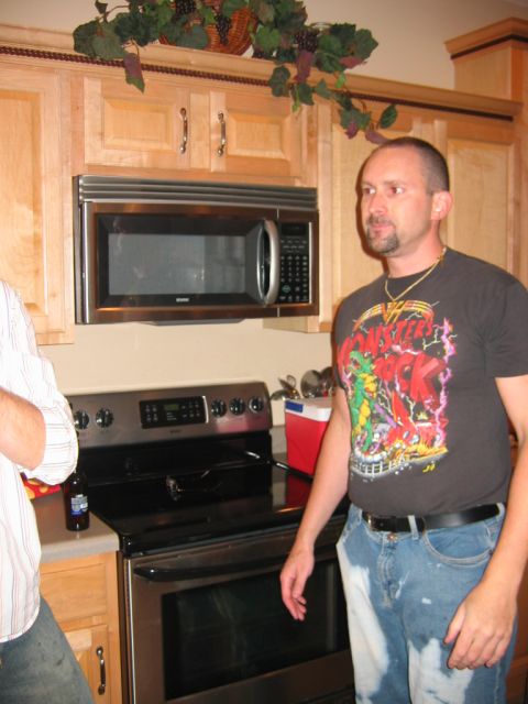 1985 Ford LTD Crown Victoria - A man stands in a kitchen with appliances and cabinets visible.