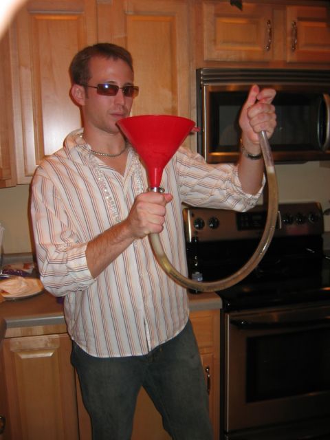 1985 Ford LTD Crown Victoria - Man uses a beer funnel in a kitchen setting.