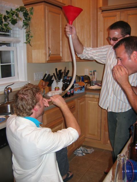 1985 Ford LTD Crown Victoria - A group of friends are participating in a beer funnel drinking game in a kitchen setting.